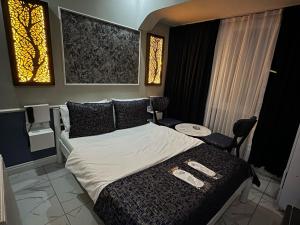 a bedroom with a bed and a table and windows at Bakırköy Otel in Istanbul