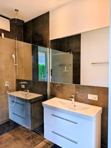 Un baño con dos lavabos y un espejo. en ALMMONTE LIGNUM Lodge, en Wagrain