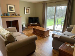 a living room with two couches and a television at Cottage 7 - Skye Cottage in Fort Augustus