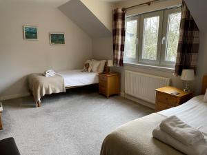 a bedroom with two beds and a window at Cottage 7 - Skye Cottage in Fort Augustus +10 photos
