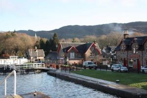 a group of houses next to a body of water at Cottage 7 - Skye Cottage in Fort Augustus