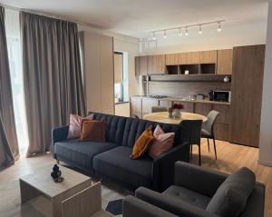 a living room with a blue couch and a table at No5District Luxury Stay in Craiova