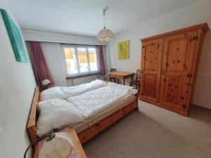 a bedroom with a bed and a window and a table at LAAX Homes - Maighels 8-9 in Laax-Murschetg +5 photos