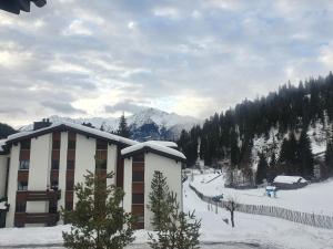 a building in the snow in front of a mountain at LAAX Homes - Maighels 8-9 in Laax-Murschetg