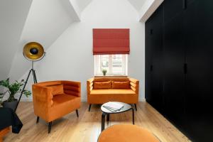 a living room with orange furniture and a window at Apartamenty Schoeps Residence by Noclegi Renters in Poznań +149 photos