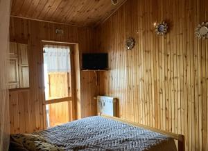 ein Schlafzimmer mit einem Bett in einer Holzwand in der Unterkunft Maison Marie Antoniette in Roccaraso