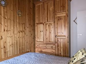 ein Schlafzimmer mit einer Holzwand und einem Bett in der Unterkunft Maison Marie Antoniette in Roccaraso + 27 Fotos