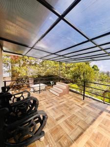 a patio with a roof with a view of trees at Costa Green Garden- Luxury 4 bedroom bungalow Mountain view in Kodaikānāl +25 photos