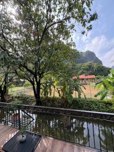 a balcony with a view of a tree and a field at Trang an mountain view bungalow in Nguyên Ngoại +8 photos