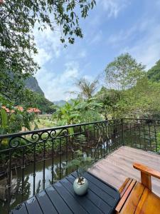 a wooden deck with a table and a bench at Trang an mountain view bungalow in Nguyên Ngoại