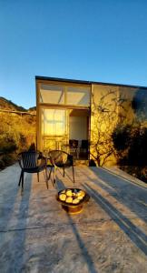 a house with two chairs and a bowl of apples on a patio at Cubos habitables 3 in San Antonio de Arredondo