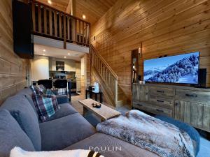 a living room with a couch and a large screen tv at Lindvallen Ski Resort - Studio - 4 Guests in Sälen