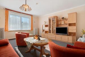 a living room with a table and a tv at Haus Frieda in Ostseebad Koserow