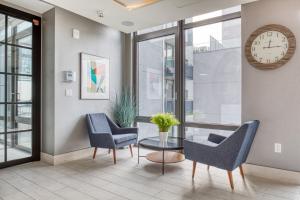 a room with two chairs and a table and a clock at LIC 1BR w Gym DM Elevator Private Balcony NYC-768 in Long Island City +30 photos