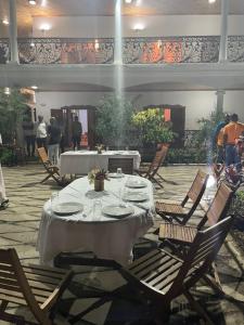 Una mesa con un mantel blanco y sillas en un patio. en Océan Voyages Mitsamihouli, en Mitsamiouli
