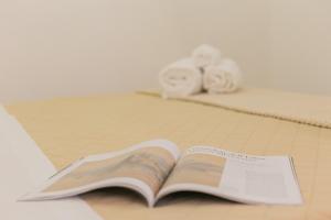 an open book on a table with two rolls of toilet paper at La Casa di Ninetta - Boutique Stay in Monopoli