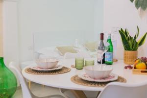 Una mesa blanca con dos cuencos y botellas de vino. en La Casa di Ninetta - Boutique Stay, en Monopoli 22 fotos más