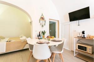 Una cocina y un comedor con mesa y sillas. en La Casa di Ninetta - Boutique Stay, en Monopoli