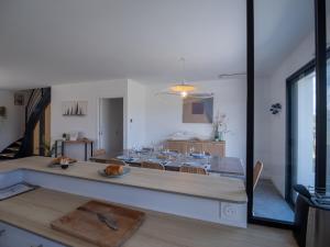 a kitchen and dining room with a table and chairs at Villa de l'Ile d'Olonne in LʼÎle-dʼOlonne