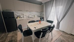 a kitchen with a white table with chairs and a refrigerator at Bilalshome in Alexandroupoli