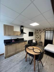 a living room with a kitchen and a table in a room at Les Pichies, Studio Dadoum, Centre ville in Digoin