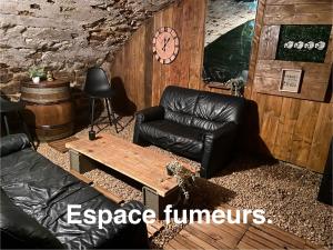 a living room with a leather couch and a table at Les Pichies, Studio Dadoum, Centre ville in Digoin