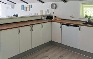Una cocina con gabinetes blancos y una encimera de madera. en Nice Home In Hadsund With 2 Bedrooms, en Hadsund 11 fotos más