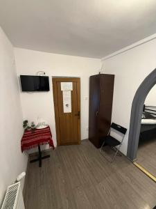 ヤシにあるCasa Bucovineanăのドア、テーブル、椅子が備わる部屋