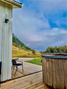 a wooden deck with a table and a bench on it at Nordhaven Retreat- Lofoten in Vestvågøya +11 photos