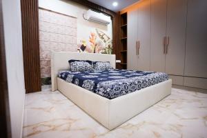 a bedroom with a bed with a blue and white comforter at Hangout Ville in Hyderabad