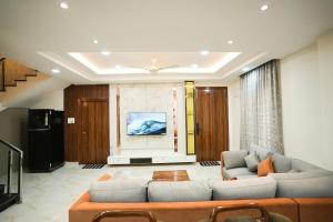 a living room with a couch and a tv at Hangout Ville in Hyderabad