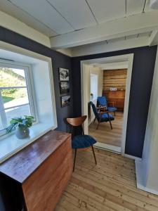 a living room with a window and a chair at Nordhaven Retreat- Lofoten in Vestvågøya
