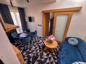 a living room with a blue couch and a table at Hotel Modriča in Modriča