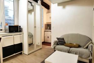 a living room with a couch and a microwave at Cute Marais Studio near Metro Heart of Paris N4-22 in Paris