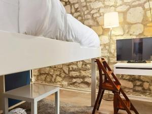 a bedroom with a bed and a desk and a chair at Cute Marais Studio near Metro Heart of Paris N4-22 in Paris