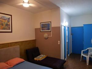 Una habitación con una cama y una silla y una puerta azul. en STUDIO FACE MARINA, en Saint-François 37 fotos más