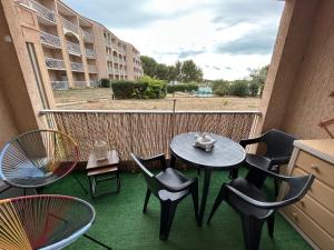 a balcony with chairs and a table and chairs at Le Moorea T2 climatisé piscine in Balaruc-les-Bains