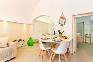 Un comedor blanco con una mesa y sillas. en La Casa di Ninetta - Boutique Stay, en Monopoli