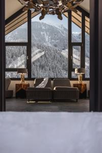 a living room with a couch and a mountain view at MYALPS Tirol inklusive Sky- Wellness in Oetz