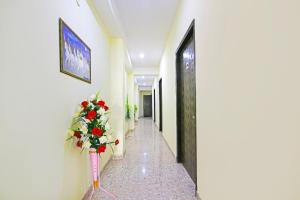 a hallway with a vase of flowers on the wall at Hotel O Gulabi Delight in Faridabad