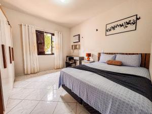 een slaapkamer met een bed en een bureau erin bij Casa com área gourmet, acomoda até 11 pessoas in Brusque +43 foto's