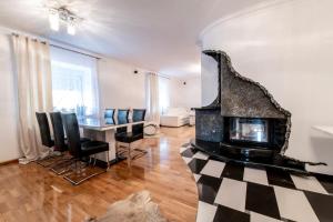 Una sala de estar con chimenea y una mesa y sillas. en Apartament Europa, en Kruszyn