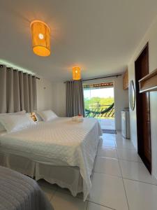 a bedroom with two beds and a large window at Atins Suites in Atins