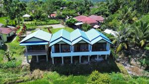 an overhead view of a house with blue roofs at Mawas Guest House Only Book Trekking With Us in Bukit Lawang