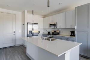 uma cozinha branca com uma pia e uma geladeira em Blueground Del Valle pool nr McKinney Falls ATX-355 em Austin