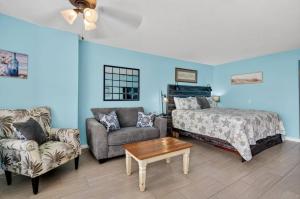 a bedroom with a bed and a couch and a table at Beachin' at The Fountain Resort in Daytona Beach