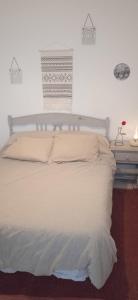 Una cama blanca en un dormitorio con ventana. en Casa Fuente del Caño, en Casarabonela