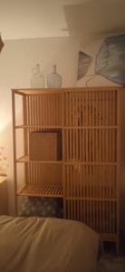 1 dormitorio con una estantería de madera con jarrones y 1 cama en Casa Fuente del Caño, en Casarabonela