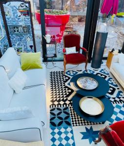 a living room with a white couch and a chair at La Maison Ruffinoise in Sainte-Ruffine