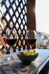 two glasses of wine and a bowl of fruit on a table at Adorable Jacuzzi flat in the most alive Athens! in Athens